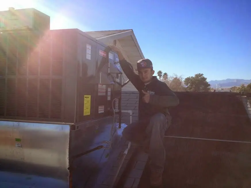 HVAC technician performing HVAC Inspection on a rooftop unit in Howard
